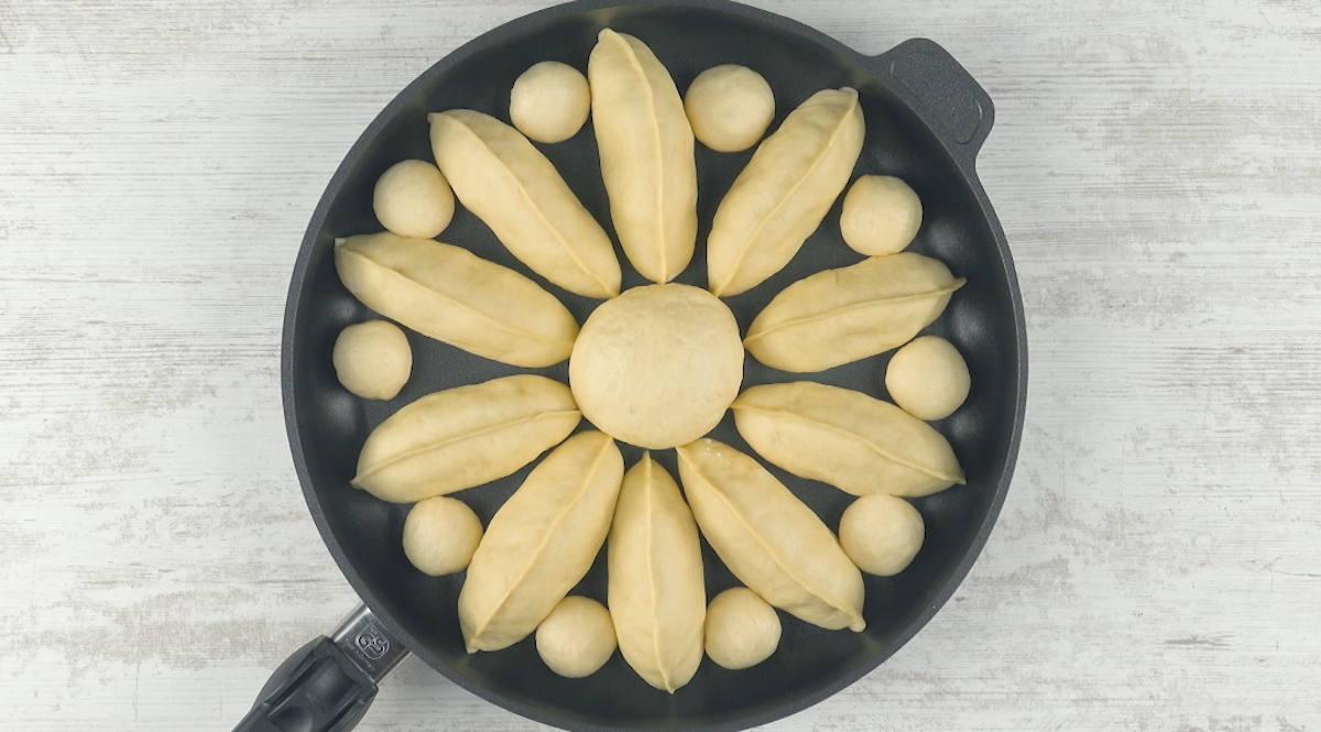 Teigpäckchen mit Äpfeln und Teigkugeln in der Pfanne