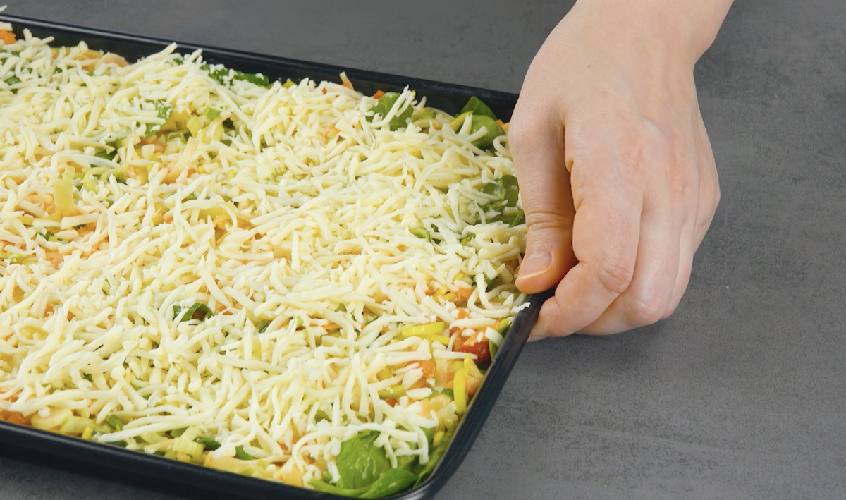 Frittata-Masse aus Backblech mit geriebenem Käse