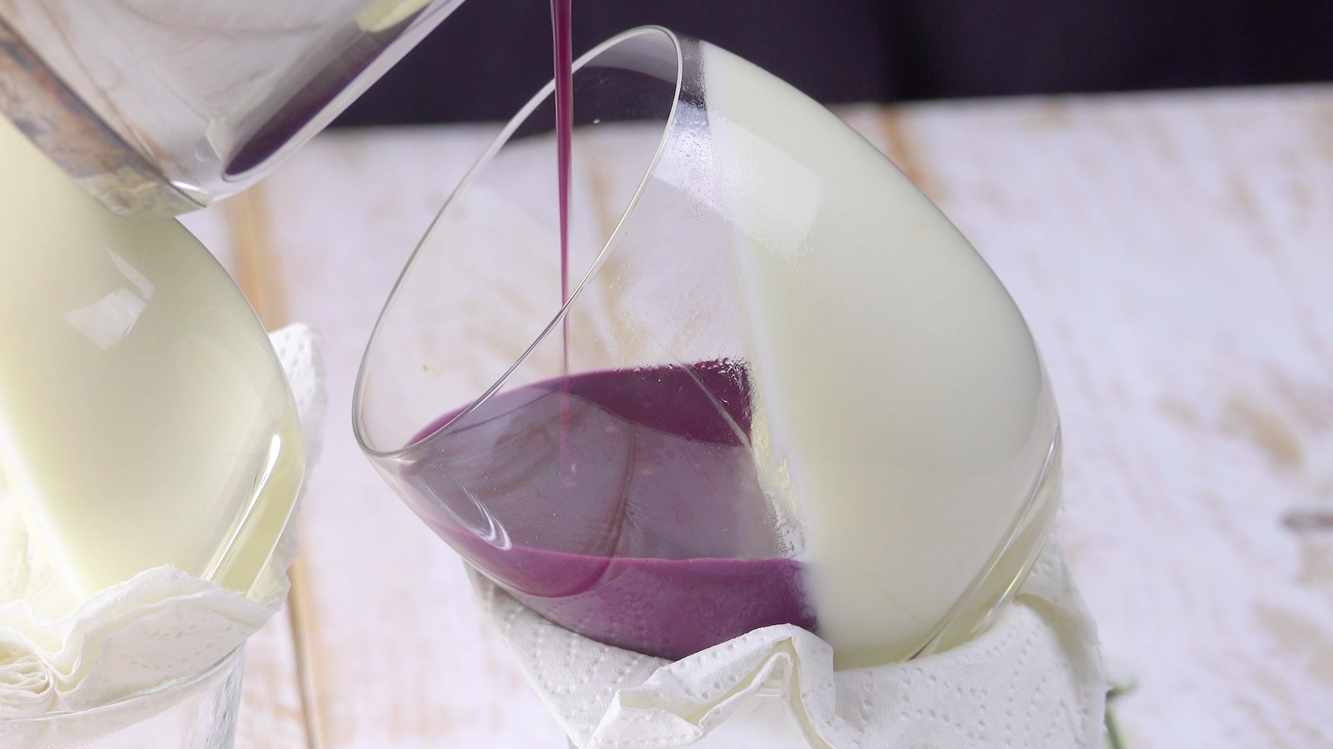 Heidelbeer-Pannacotta wird schräg in Dessertglas gegossen