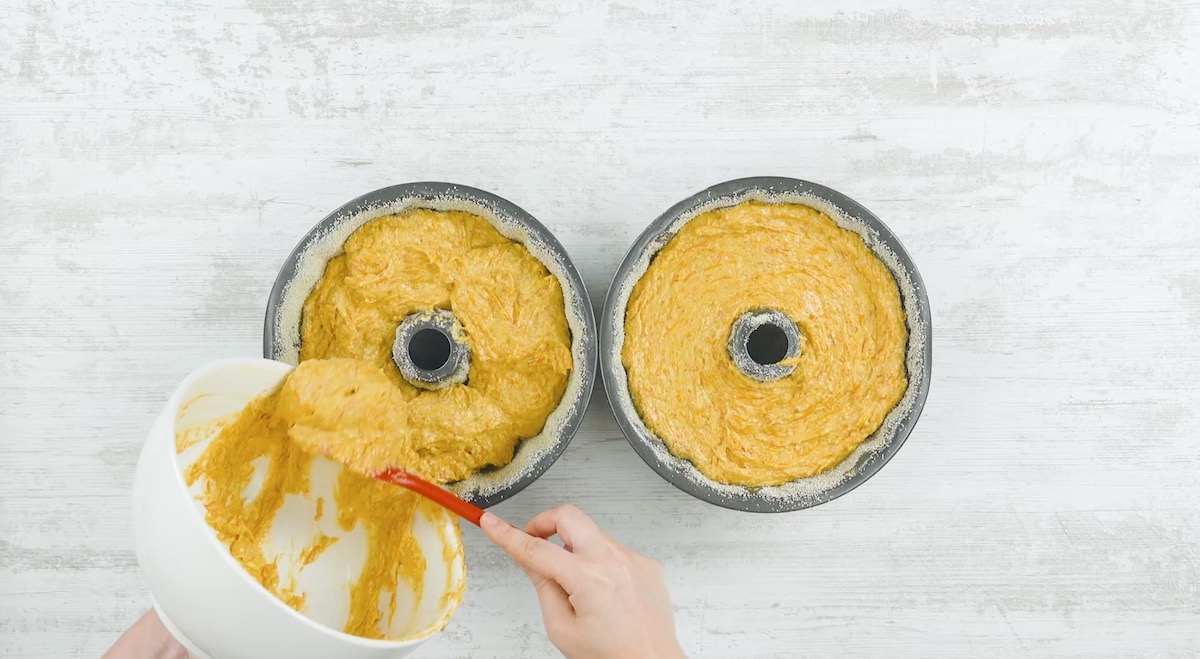 Kuchenteig wird auf zwei Gugelhupf-Formen vertelt