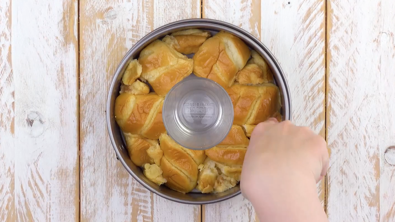 Milchbrötchen werden kreisförmig um Glas herum in Kuchenform platziert