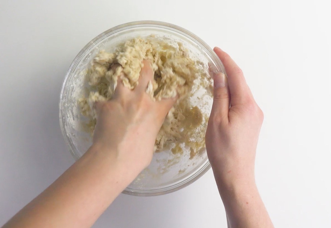 Zutaten für einen Hefeteig werden in einer Schüssel miteinander verknetet.