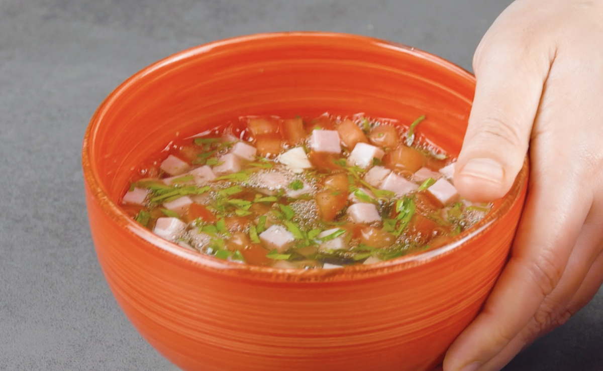 Schinken- und Tomatenwürfel werden mit Petersilie und Eiweiß in Schüssel gegeben