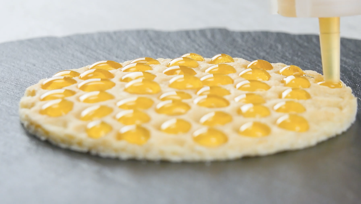 Mulden eines Kekses werden mit Honig gefüllt