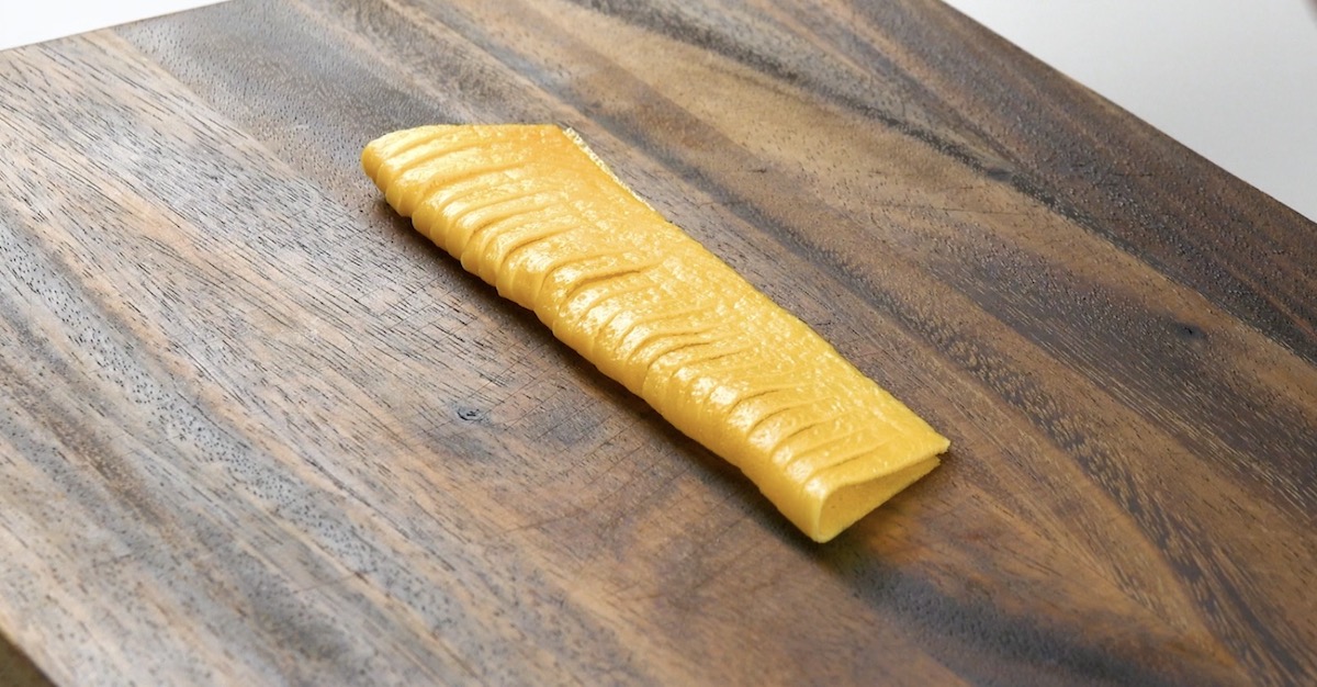 Das gefaltete Omelett wird in regelmäßigen Abschnitten bis zur Hälfte eingeschnitten