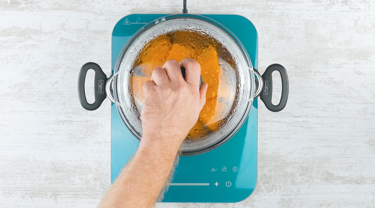 Butternutkürbis in Stücken wird in Topf gegart