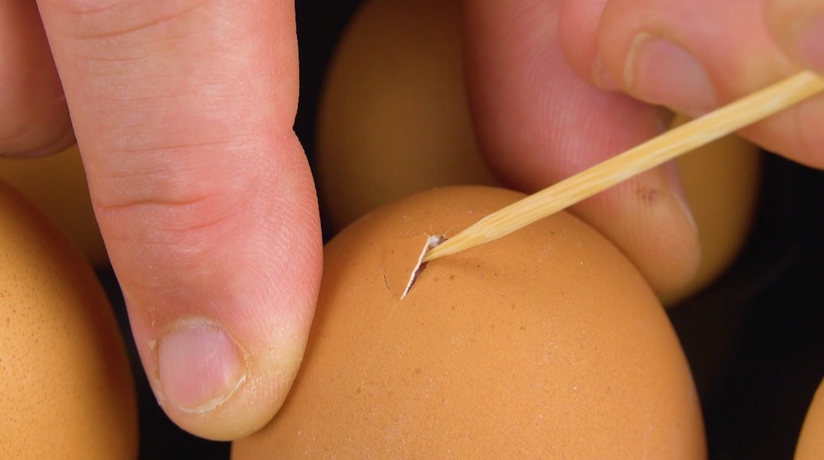 Mit Schaschlikspieß wird Loch in Ei gepikst