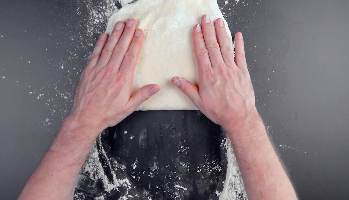 Plattierte Butter wird auf eine Hälfte ausgerollten Teigs gelegt und mit anderer Hälfte des Teigs bedeckt