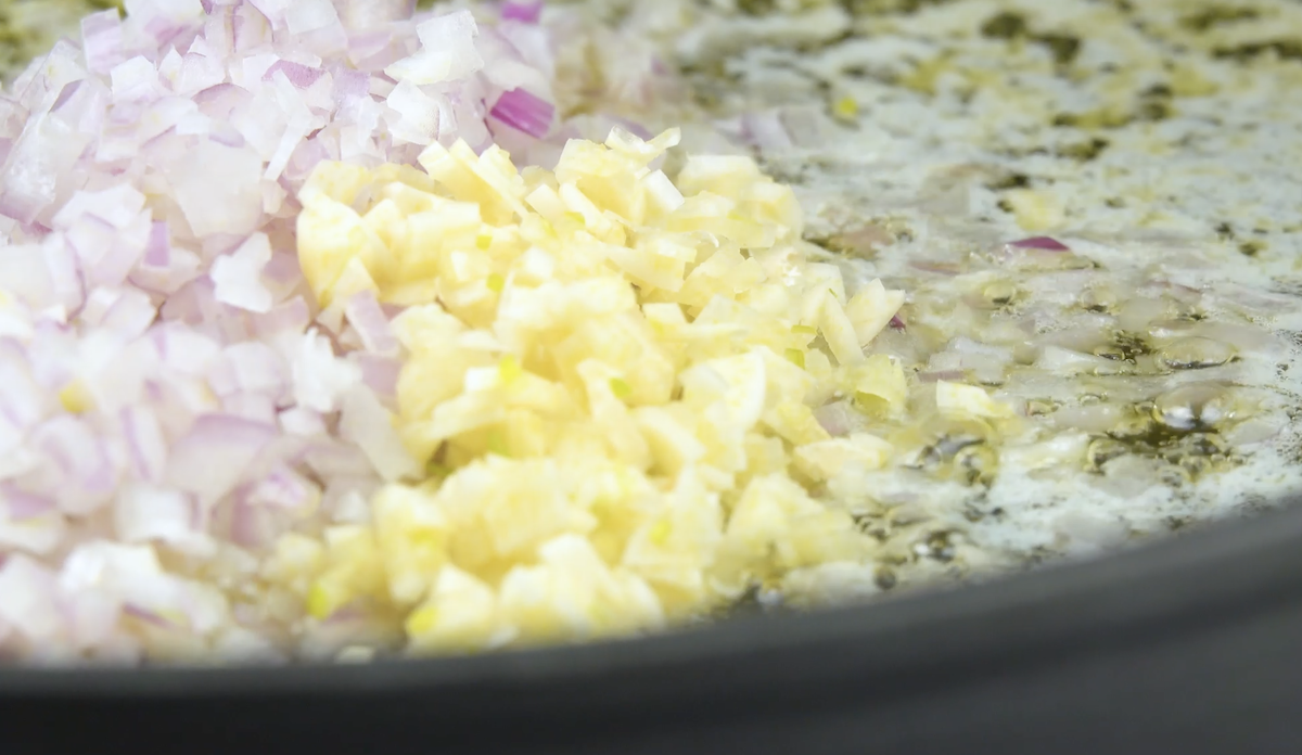 Klein gehackte Zwiebeln und Knoblauch werden in Pfanne angedünstet