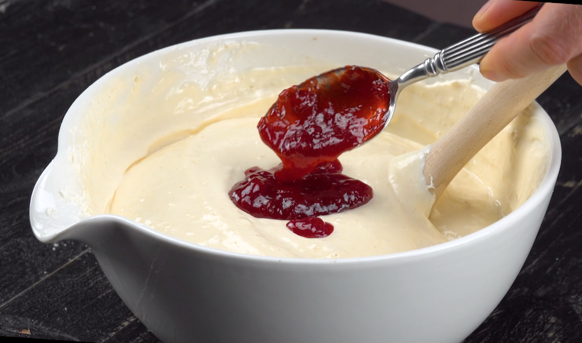 Rote Marmelade wird zum flüssigen Teig hinzugegeben