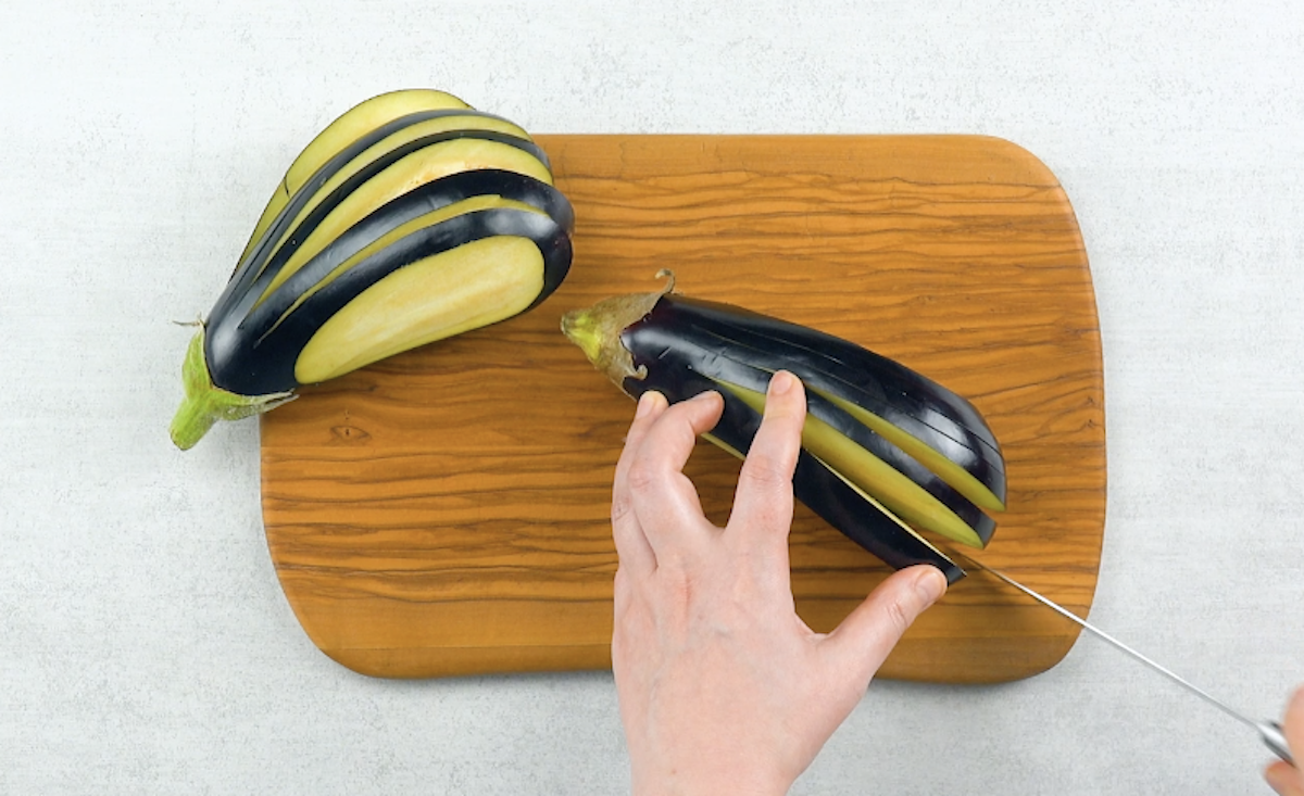 Zwei Auberginen werden mit Messer längs 7-mal eingeschnitten