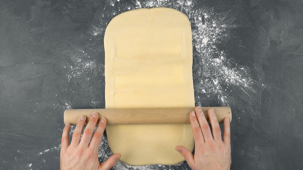 Mit Butter gefüllter Teig wird ausgerollt.