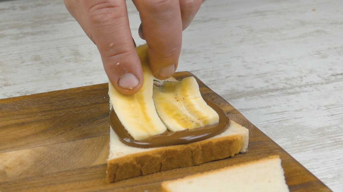 Die größere Hälfte wird mit Nutella bestrichen und Bananenscheiben belegt
