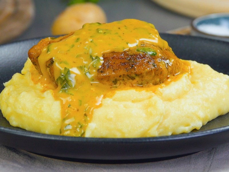 Hähnchenschenkel in Parmesan-Sahnesoße mit Kartoffelbrei.