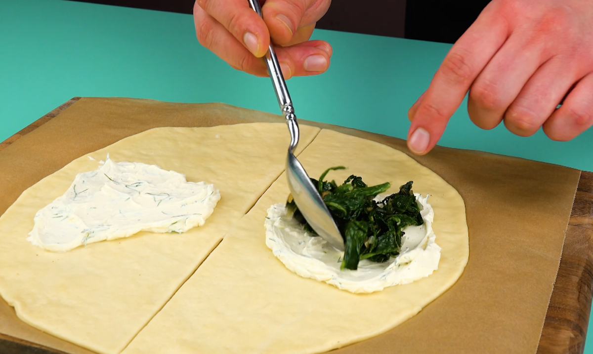 Spinat wird auf Frischkäse gegeben.