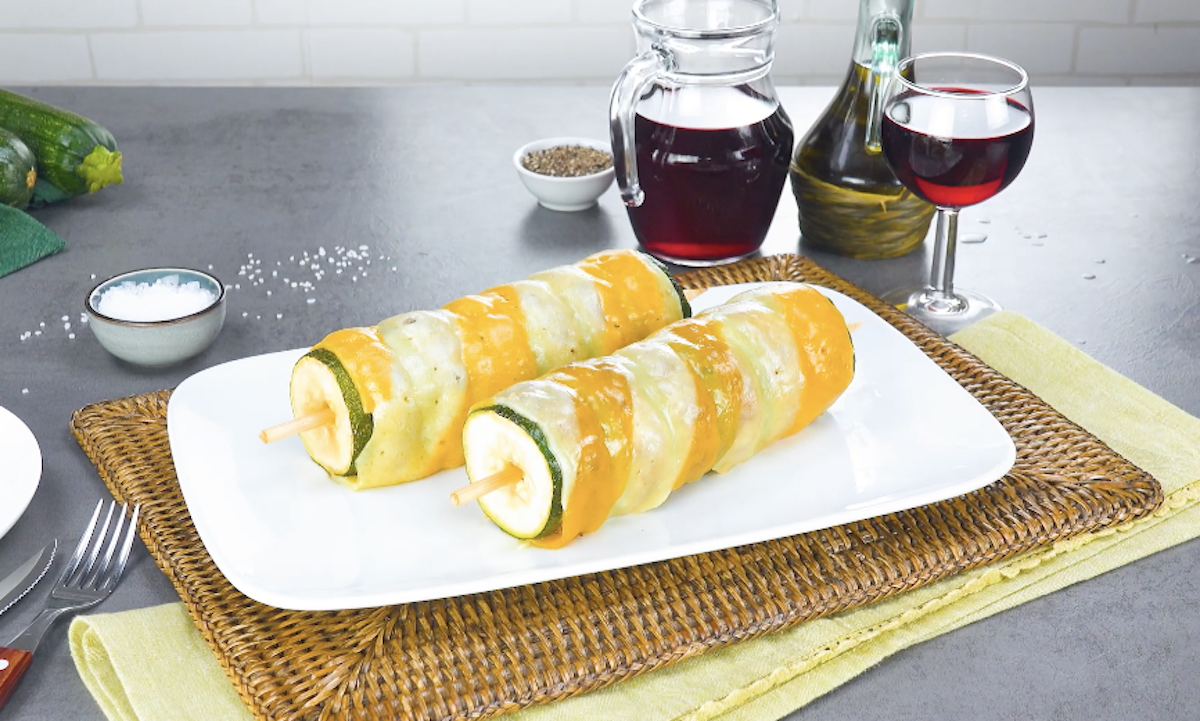 2 Zucchini-Hackfleisch-Spieße mit Käsemantel auf einem Teller