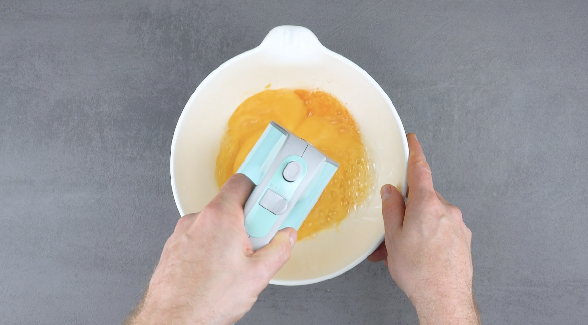 Eier werden in Schüssel mit Handrührgerät schaumig geschlagen