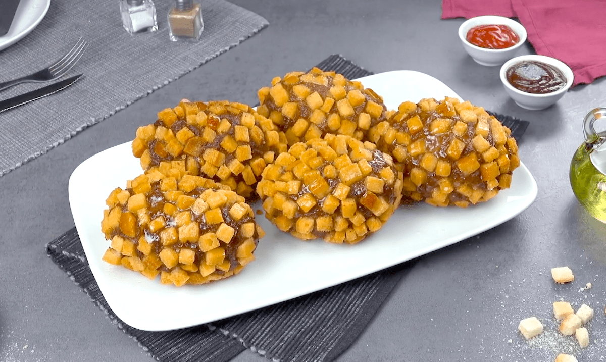 Mit Käse gefüllte Kartoffeln in Hack-Mantel in frittierter Croûton-Kruste