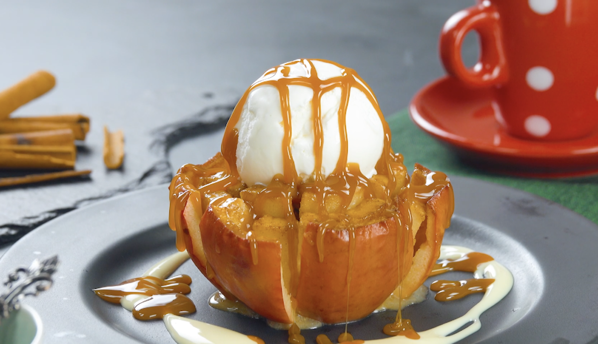 Blumiger Apfel mit Karamell-Füllung, einer Kugel Vanilleeis und Karamellsoße