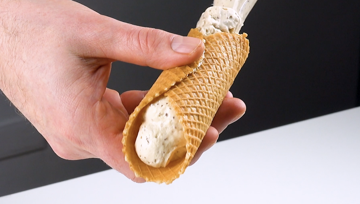 Waffel-Zylinder wird mit Creme gefüllt