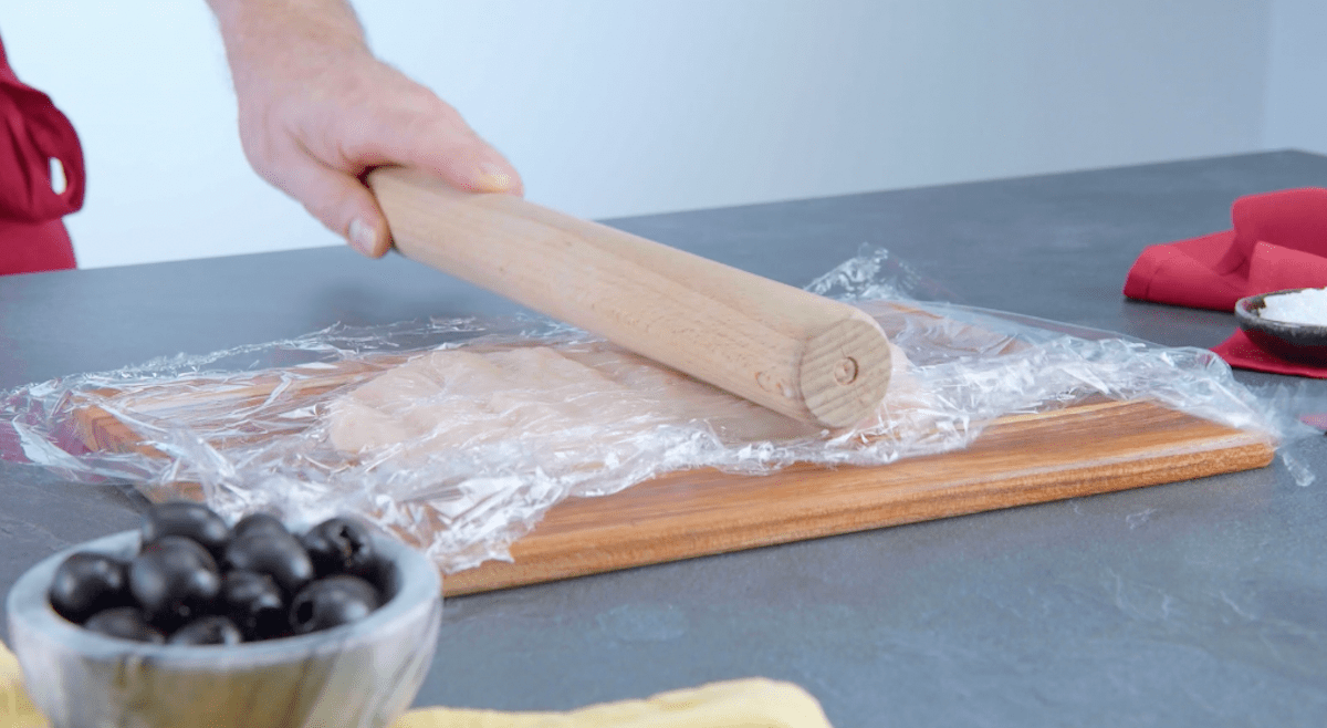 Hähnchenfleisch wird mit einem Nudelholz geplättet