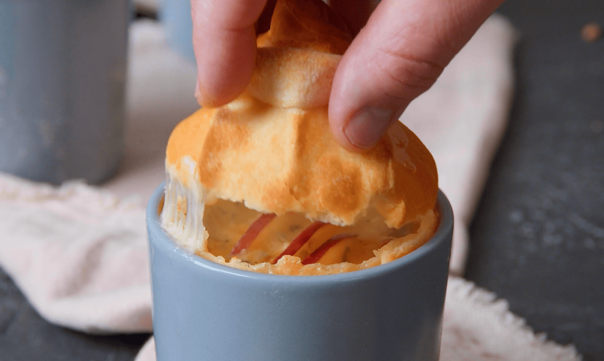 Tasse, die mit Apfel, Käse und Hefeteig gefüllt ist