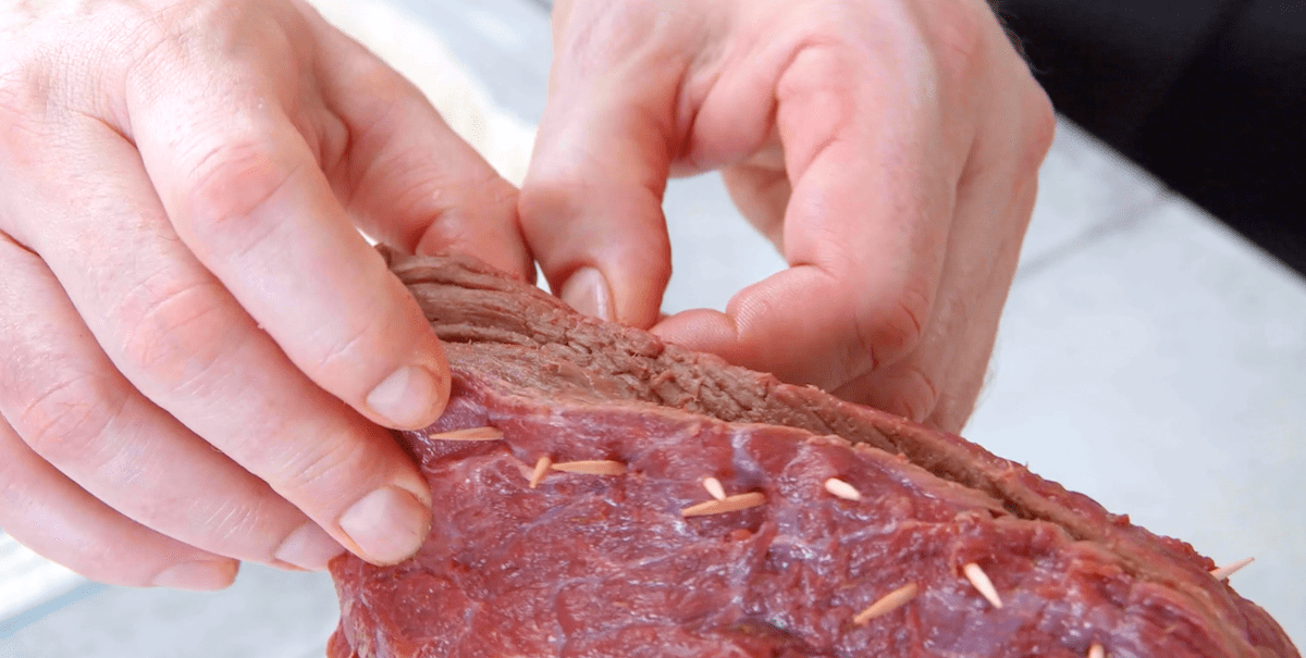 Der mit Kartoffelgratin gefüllte Tafelspitz wird an der Schnittstelle mit Zahnstochern verschlossen.