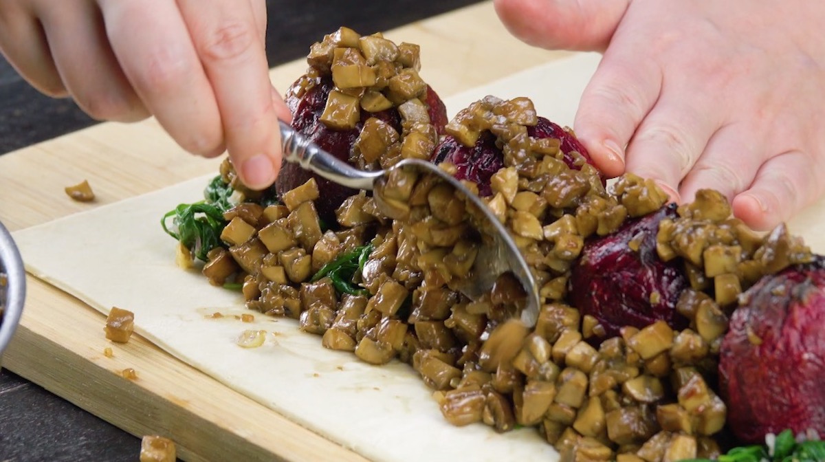Rote Bete, Champignons und Spinat werden auf Blätterteig positioniert