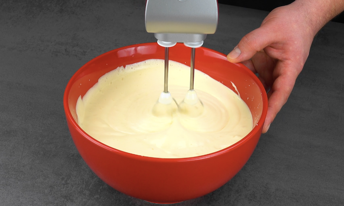 Teig wird in einer Schüssel mit dem Handrührgerät zu einer schaumigen Masse geschlagen