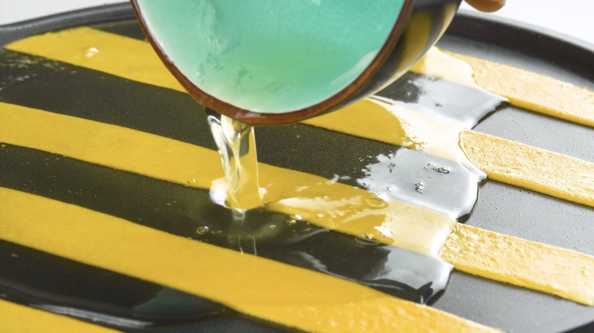 Eiweiße werden über geronnenes Eigelb in Pfanne gegossen