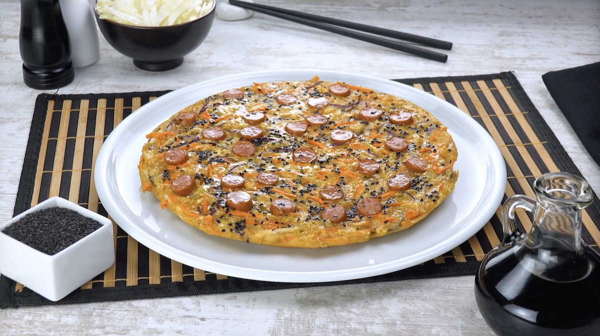 Chinakohl-Frittata auf Teller mit WÃ¼rstchen, die wie eine Salami-Pizza aussieht