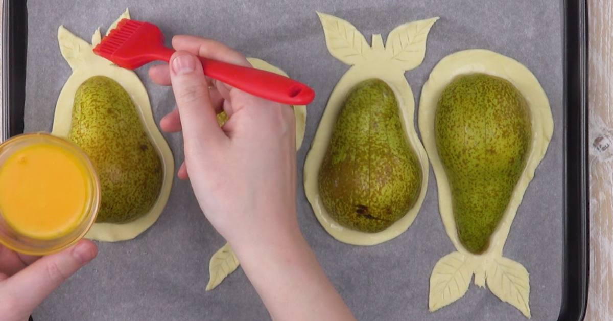 Blätterteig wird mit verquirltem Ei bestrichen