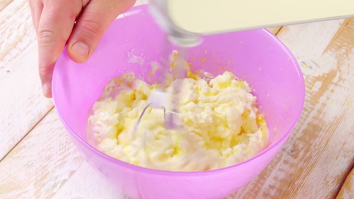 Frischkäsecreme wird mit Mixer in Schüssel zubereitet