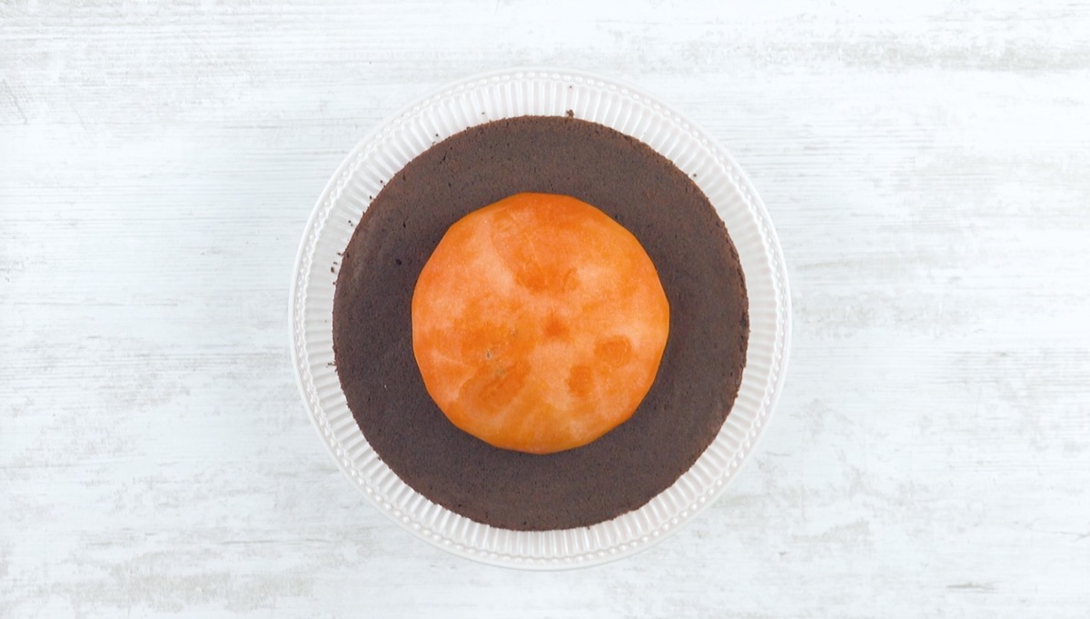 Halbierte und geschälte Wassermelone wird auf dem Brownie-Boden platziert