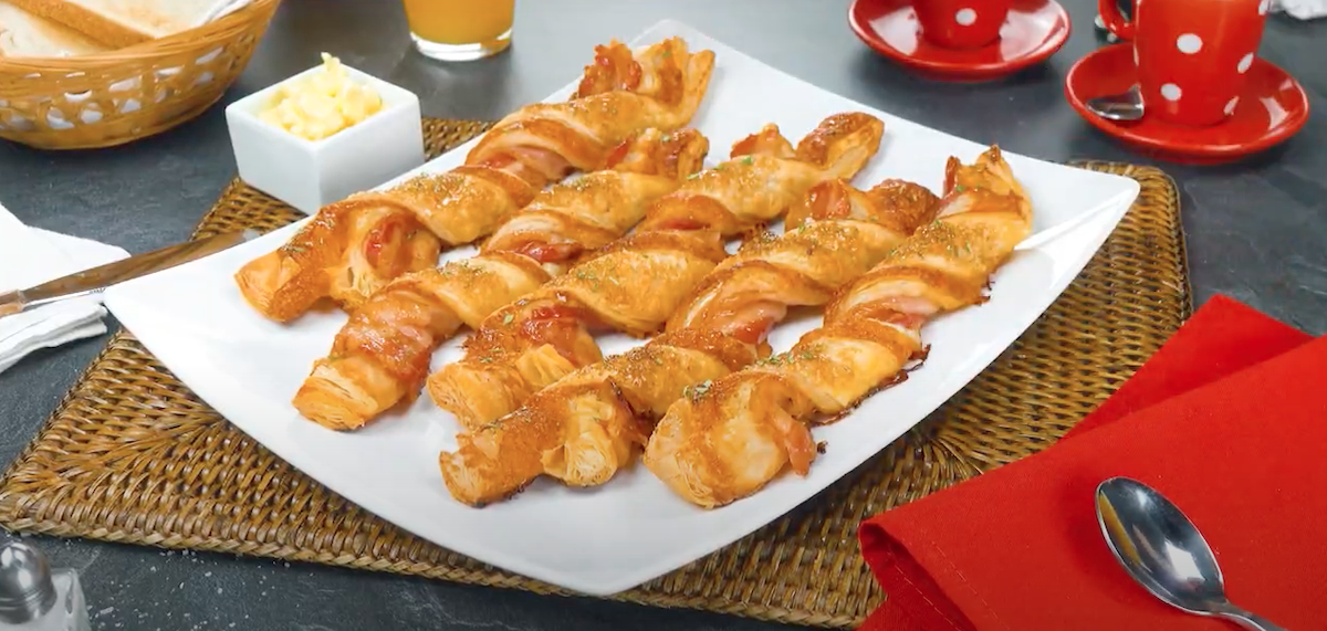 5 fertige Bacon-Blätterteig-Stangen auf einem Teller