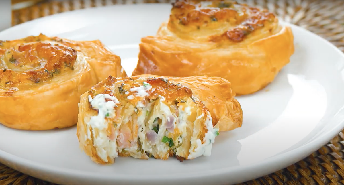 3 fertige Käse-Bacon-Wirbel, einer davon angebissen