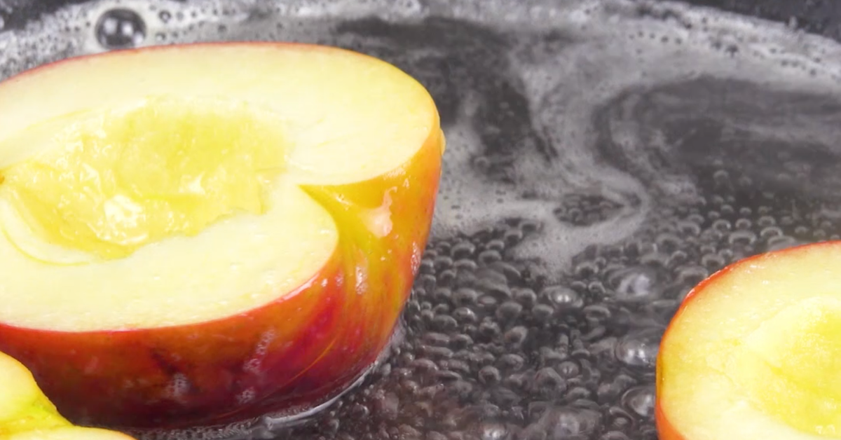 Apfelhälften werden in Wasser, Zucker und Zitronensaft gekocht