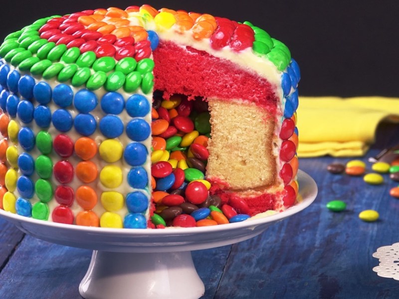 Angeschnittener Überraschungskuchen mit Smarties verziert