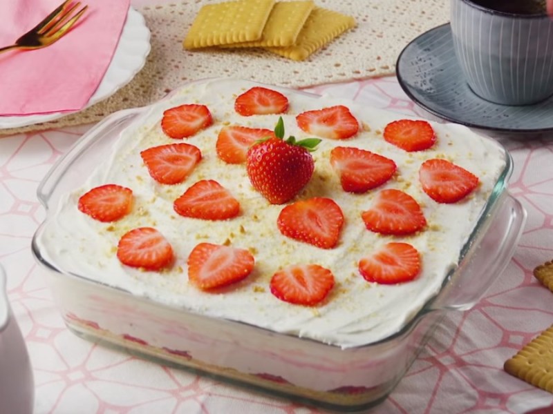 Ein Erdbeer-Käsekuchen mit Keksboden in einer eckigen Form.