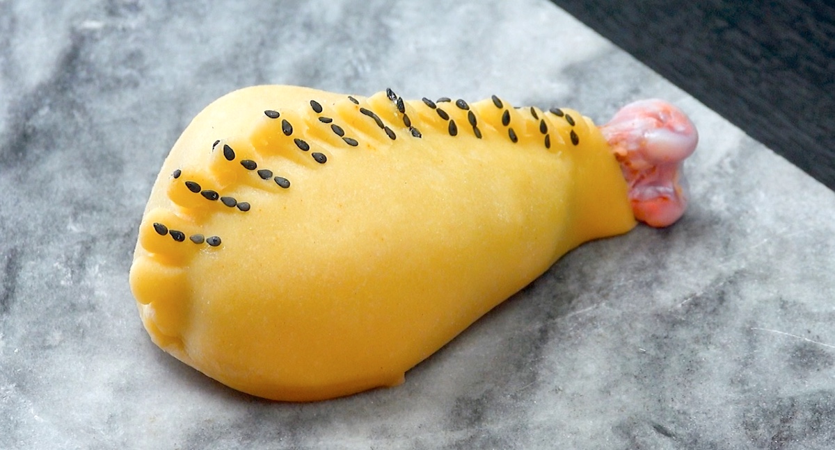 Teigkamm wird zusammengedrÃ¼ckt und so mit schwarzem Sesam garniert, das die Keule aussieht wie zugenÃ¤ht