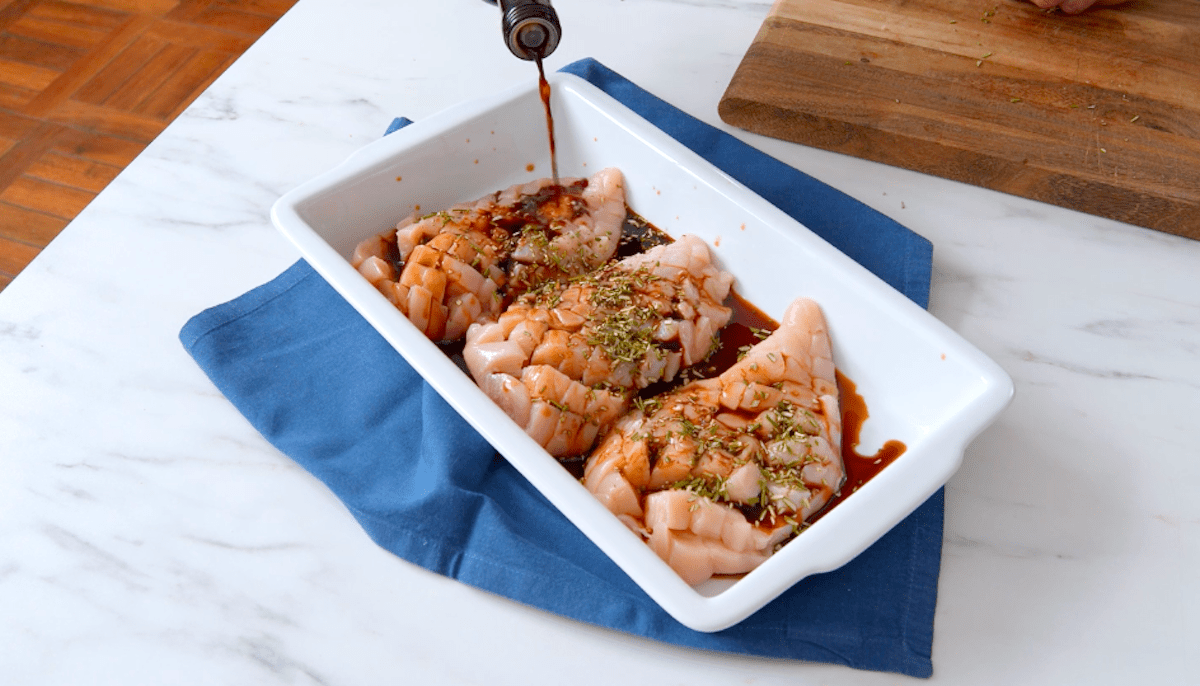 Rohe Hähnchenbrüste werden in einer Schüssel mit Essig mariniert