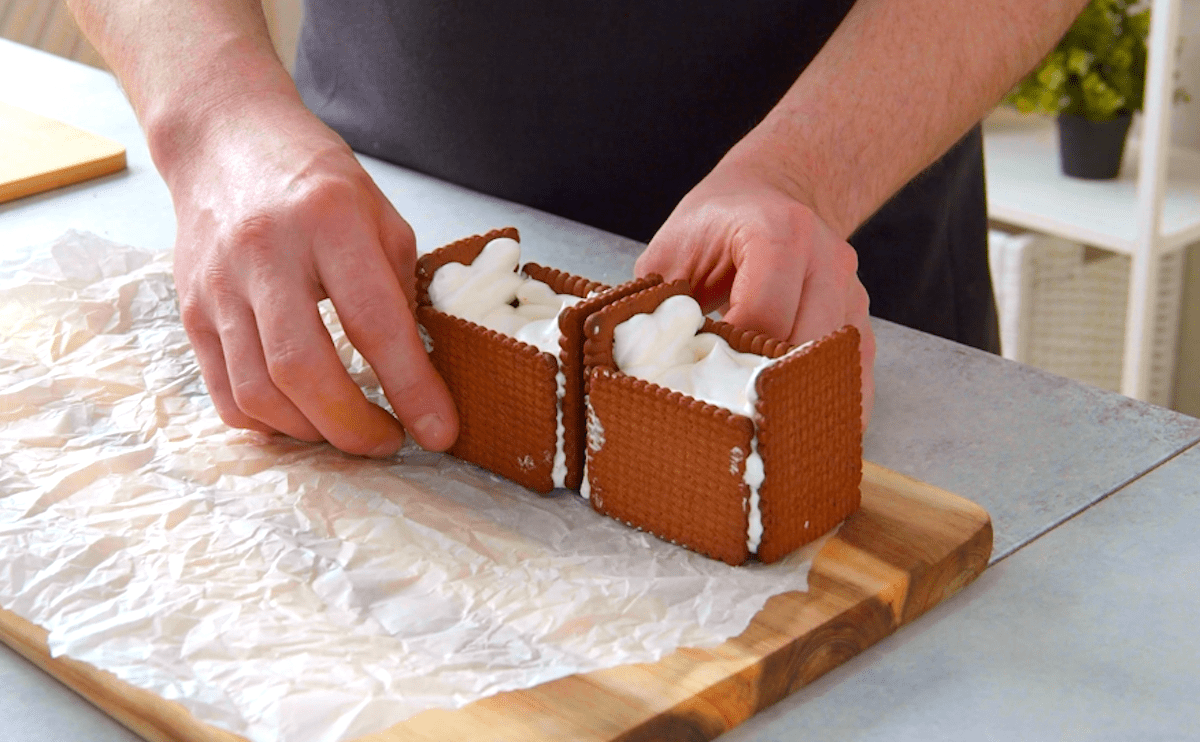 Keks-Körbchen mit Frischkäsecreme werden aneinandergereiht.