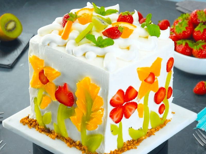 4 fantatische Obstkuchen-Rezepte. Hier ist ein quadratischer Obstkuchen mit bunter Dekoration zu sehen.