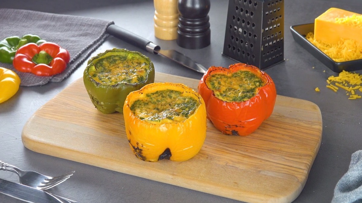 5 Ideen für Eier auf dem Grill: mit Ei gefüllte Paprikaschoten auf einem Holzbrett.