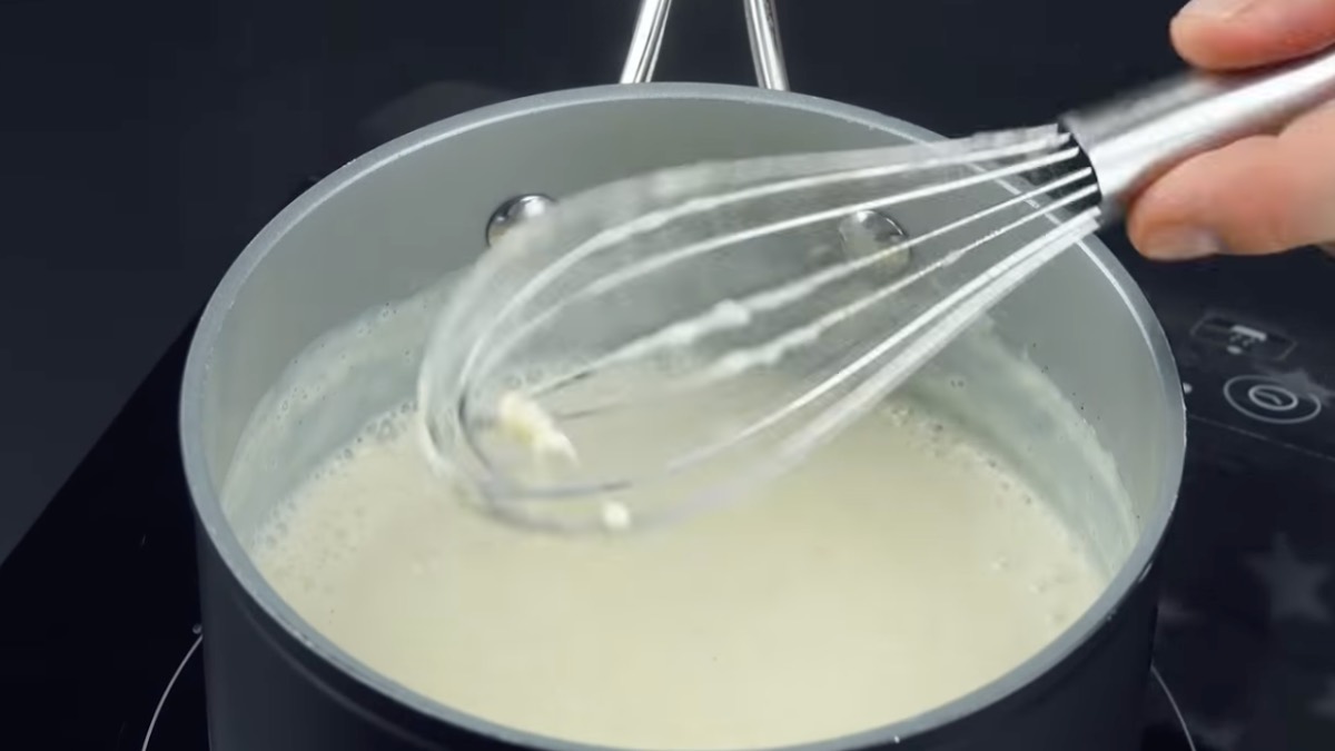 Vanillesoße im Topf wird mit Schneebesen umgerührt