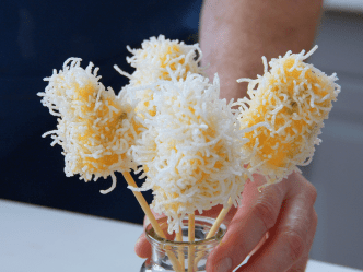 Vier Käsespieße stehen in einem Glas.