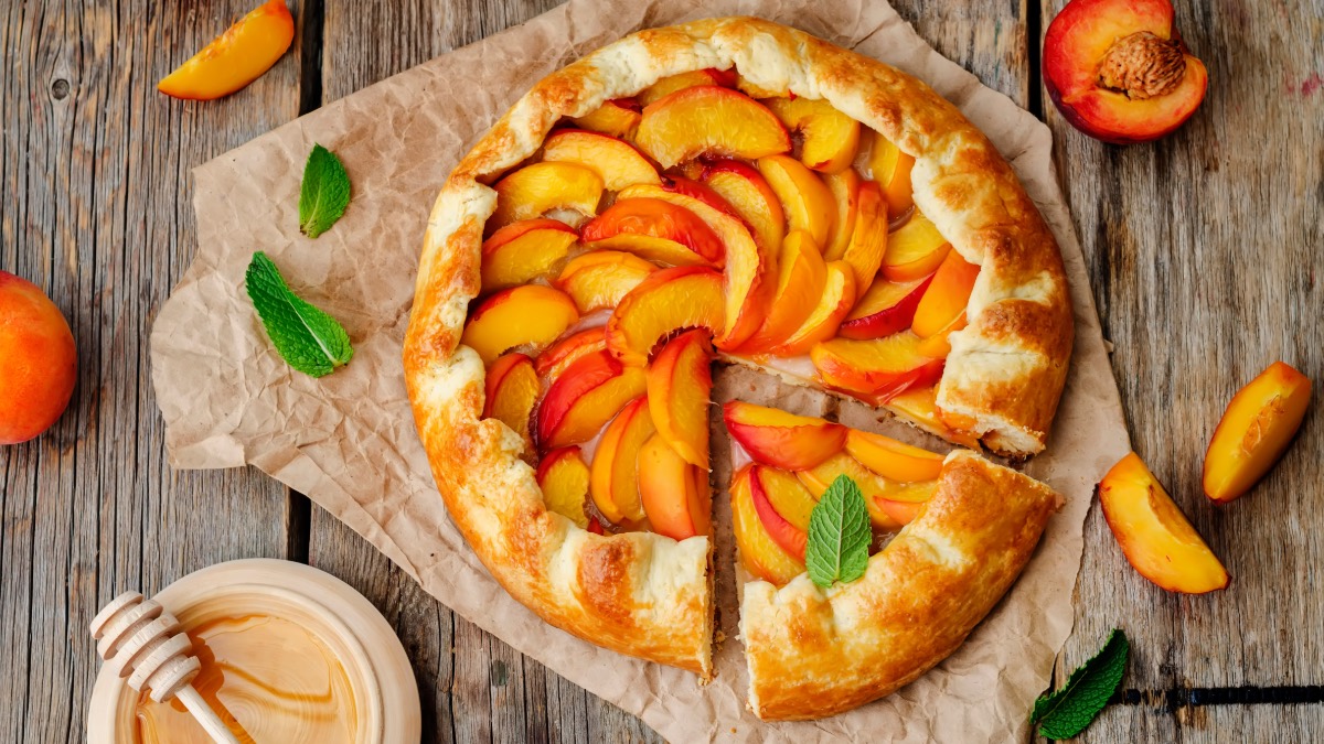 Angeschnittene Pfirsich-Crostata auf Backpapier