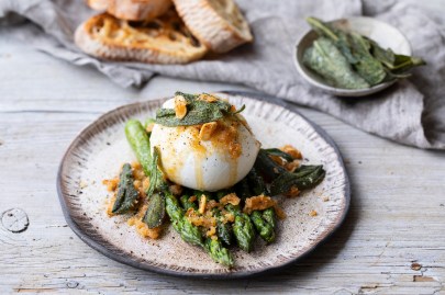 Spargel mit Burrata auf einem Teller.