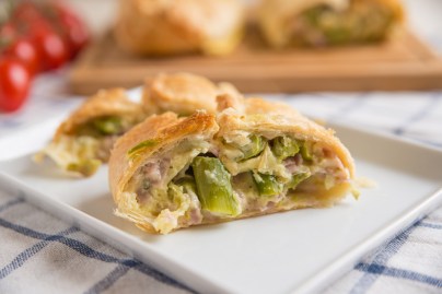 Weißer Teller mit aufgeschnittenem Spargelstrudel.