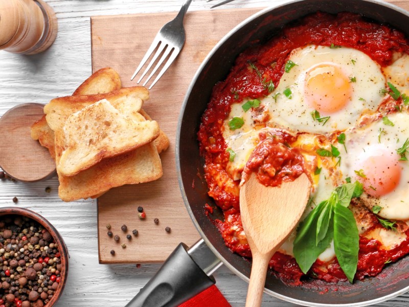 Eine Pfanne mit pochierten Eiern im Fegefeuer aus einer roten Tomatensoße.